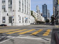 two cyclists riding down the street next to a stoplight on either side of the street