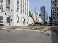 two cyclists riding down the street next to a stoplight on either side of the street