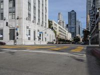 two cyclists riding down the street next to a stoplight on either side of the street