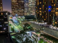 a view of the highway at night with buildings in the background and lights lit up