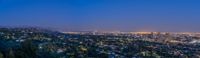 the view from the hill near downtown los looking on at night with the hollywood sign and lights from the hollywood tower