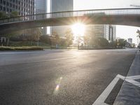 a street filled with a bridge over a road filled with tall buildings on both sides
