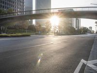 a street filled with a bridge over a road filled with tall buildings on both sides