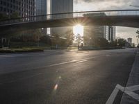 a street filled with a bridge over a road filled with tall buildings on both sides