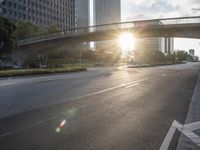 a street filled with a bridge over a road filled with tall buildings on both sides