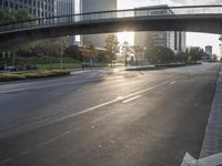 a street filled with a bridge over a road filled with tall buildings on both sides