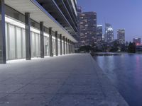 a person sitting on a skateboard in a courtyard next to an open area with tall buildings