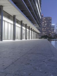 a person sitting on a skateboard in a courtyard next to an open area with tall buildings