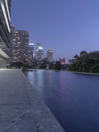 a person sitting on a skateboard in a courtyard next to an open area with tall buildings