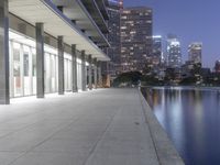 a person sitting on a skateboard in a courtyard next to an open area with tall buildings