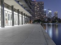 a person sitting on a skateboard in a courtyard next to an open area with tall buildings