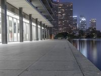 a person sitting on a skateboard in a courtyard next to an open area with tall buildings