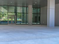 two grey blocks sitting next to a tall building on a sidewalk in front of grass