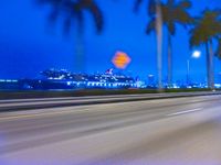 an image of an evening scene with traffic on the highway and cruise liner in the background