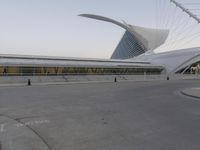 an empty parking lot in front of an ornate building with curved white and gold roof