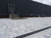 an image of some stairs and a building that is next to a sidewalk area with stone flooring
