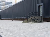 an image of some stairs and a building that is next to a sidewalk area with stone flooring