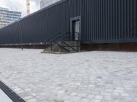 an image of some stairs and a building that is next to a sidewalk area with stone flooring