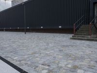 an image of some stairs and a building that is next to a sidewalk area with stone flooring