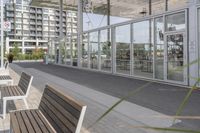 a white bench sitting on top of a sidewalk in front of tall buildings or office