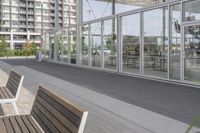 a white bench sitting on top of a sidewalk in front of tall buildings or office