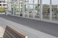 a white bench sitting on top of a sidewalk in front of tall buildings or office