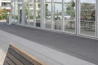 a white bench sitting on top of a sidewalk in front of tall buildings or office