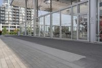 a white bench sitting on top of a sidewalk in front of tall buildings or office