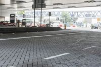 an empty street with vehicles parked next to a road divider, and a traffic light