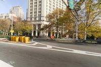 there is a street with trees and buildings on it and a red bus going by