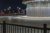 a street light and a white building lit up at night with bright lights around it