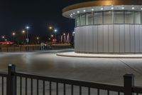 a street light and a white building lit up at night with bright lights around it