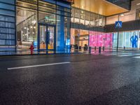 people walk outside a shopping mall that has been converted into a building in the evening