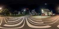 a street view of a city at night, taken from a moving skateboarder in the foreground