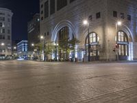 a person rides an atv down the street at night near the city square and skyscrapers