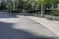 a car driving down an empty street lined with tall buildings and trees in the background