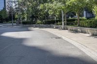 a car driving down an empty street lined with tall buildings and trees in the background