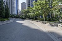 a car driving down an empty street lined with tall buildings and trees in the background