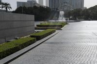 a large brick area next to a park in a city setting with buildings on either side
