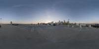 the view from a parking lot to the large cityscape as seen in a fish eye view