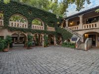 a courtyard with many arches and doors on it that is covered in ivy and stone