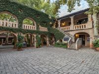 a courtyard with many arches and doors on it that is covered in ivy and stone