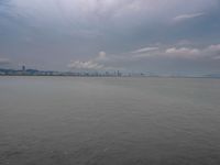 the water has very large chunks of blue in it and a skyline of large buildings in the background