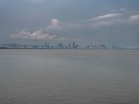 the water has very large chunks of blue in it and a skyline of large buildings in the background