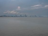 the water has very large chunks of blue in it and a skyline of large buildings in the background