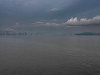 the water has very large chunks of blue in it and a skyline of large buildings in the background