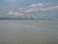 the water has very large chunks of blue in it and a skyline of large buildings in the background