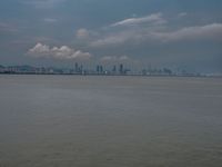 the water has very large chunks of blue in it and a skyline of large buildings in the background