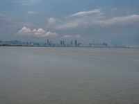 the water has very large chunks of blue in it and a skyline of large buildings in the background