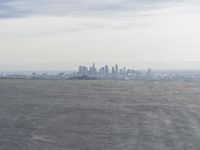 Cityscape Skyline Overlooking Asphalt Plain with Calm Sea